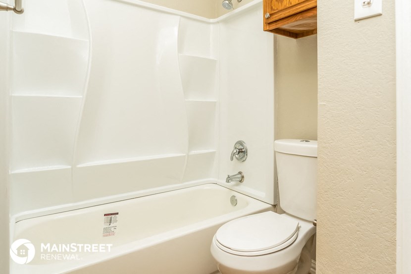 a bathroom with a tub and a toilet and a sink