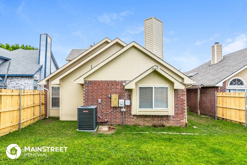 the outside of a house with a yard and a water heater