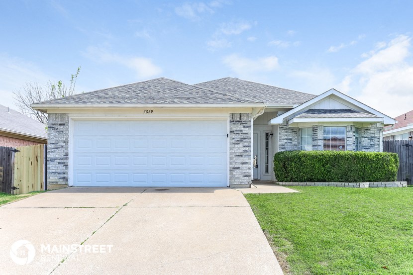 a house with a white garage door and a lawn