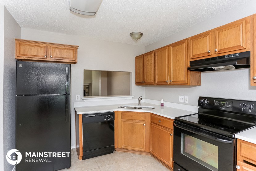 a kitchen with black appliances and wooden cabinets