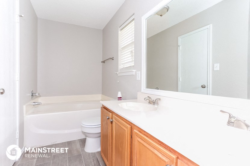 a bathroom with a sink toilet and a mirror