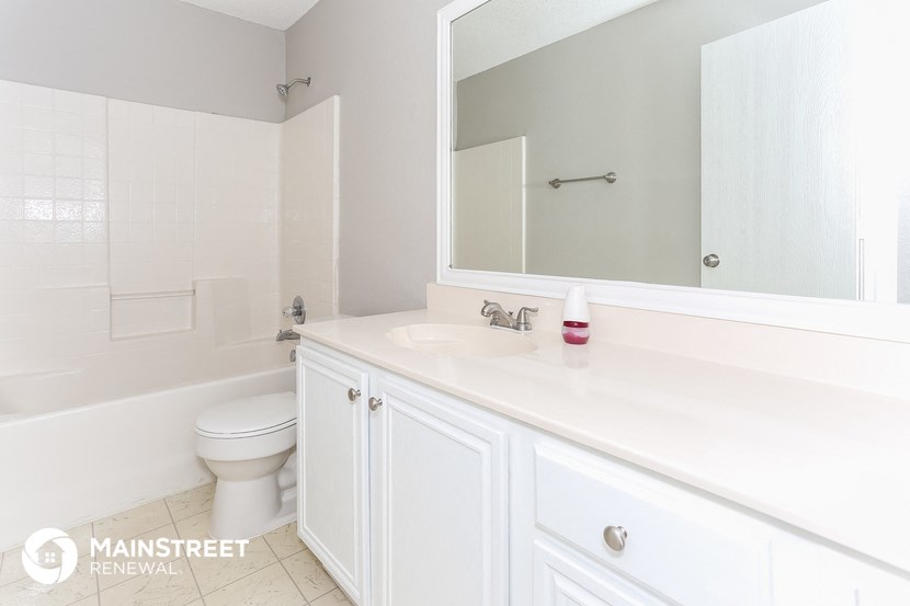 a white bathroom with a white sink and a toilet