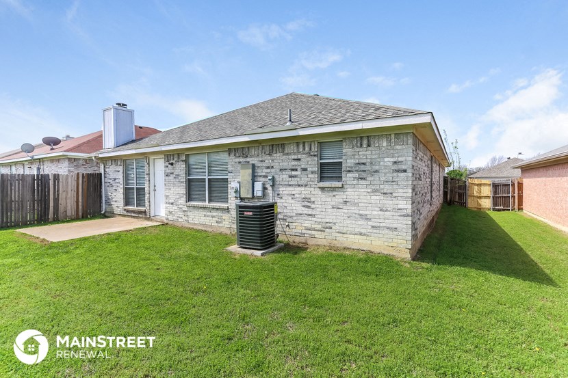 a small brick house with a backyard and a water heater