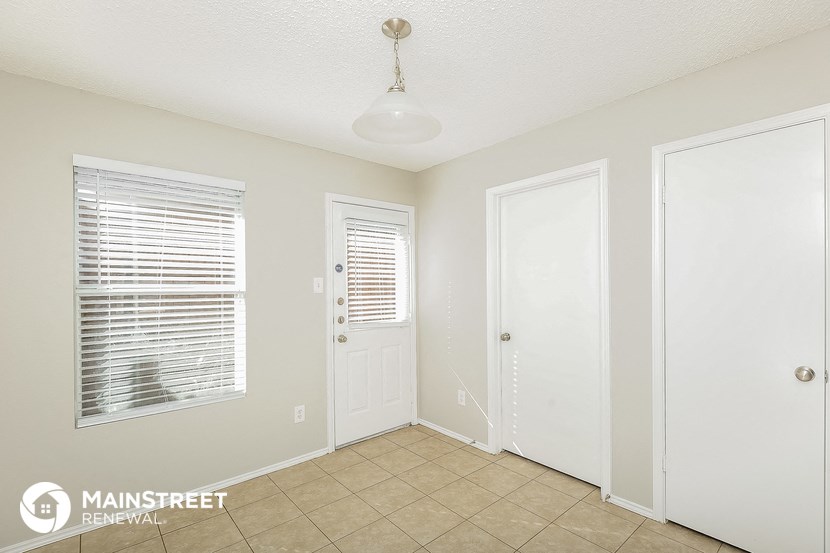 a small room with a tile floor and a white door