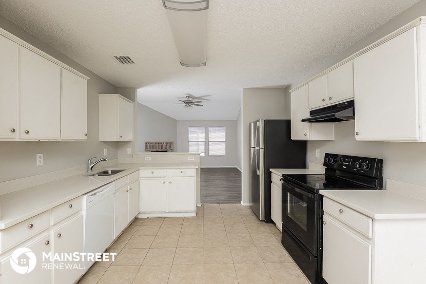 a white kitchen with black appliances and white cabinets
