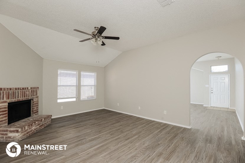 the living room with fireplace and ceiling fan