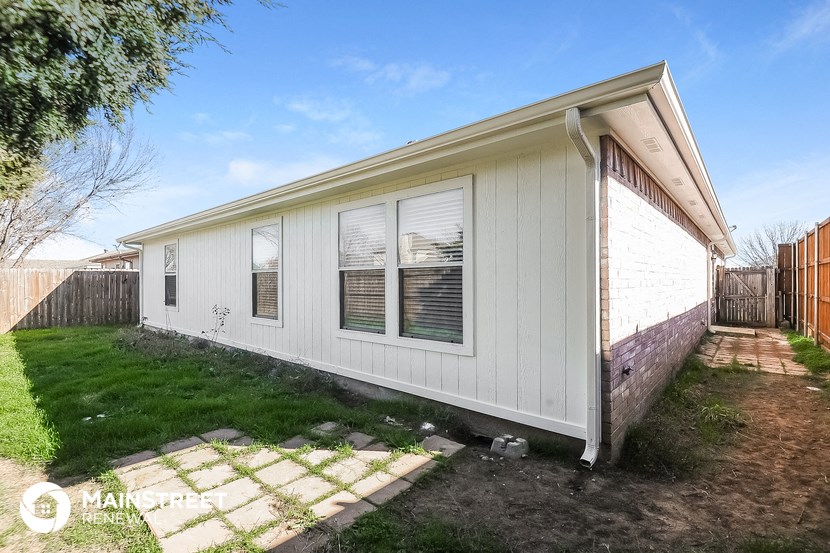 a small white house with a backyard and a fence