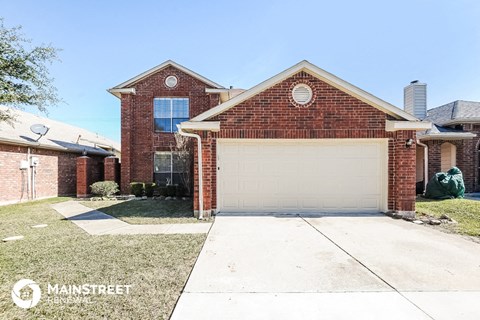 a small brick house with a white garage door