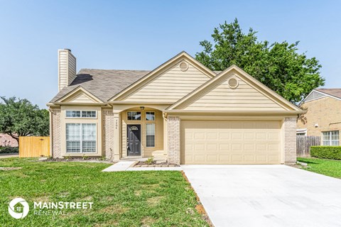 a beige house with a driveway and a lawn