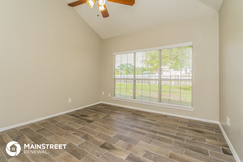 the living room of an empty house with a large window