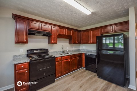 a kitchen with black appliances and wooden cabinets