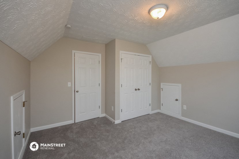 a bedroom with two closets and a carpeted floor