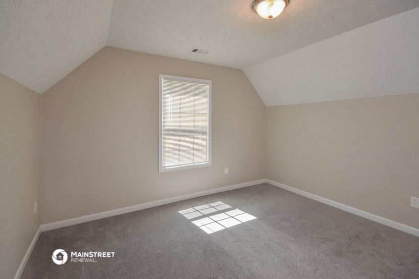 the upstairs bedroom with carpet and window