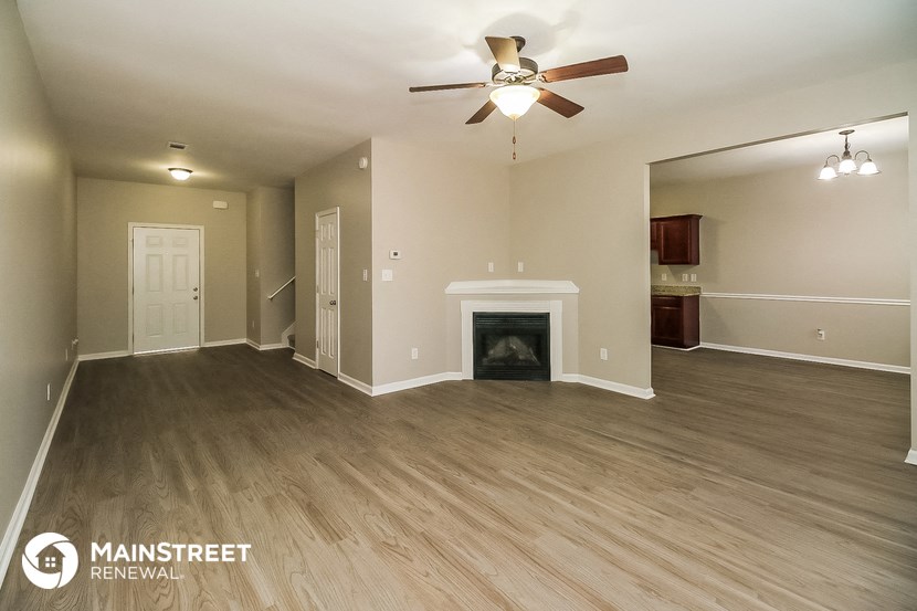 a living room with a fireplace and a ceiling fan