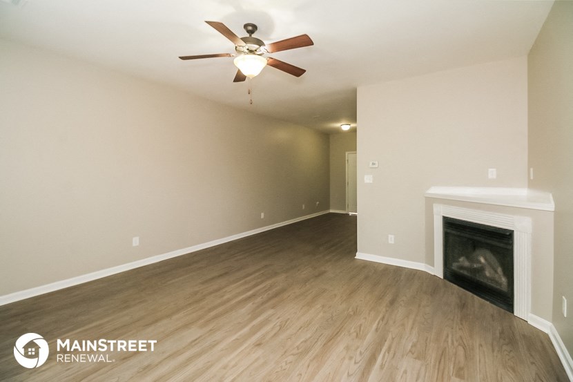 the living room with fireplace and ceiling fan