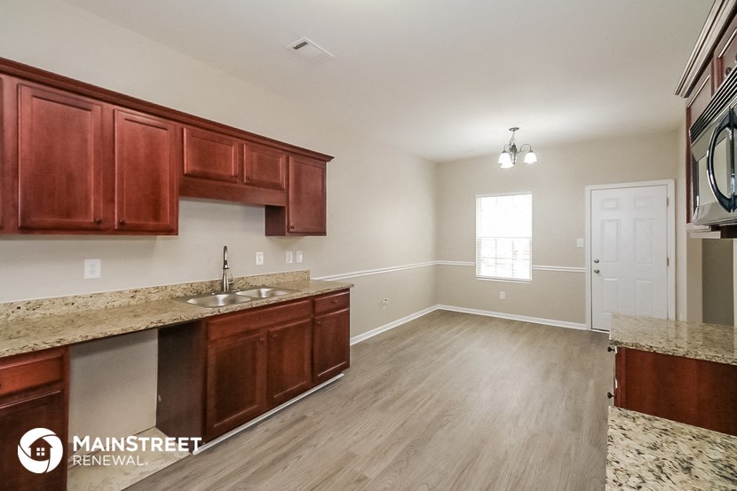a kitchen and living room with wood flooring and granite counter tops