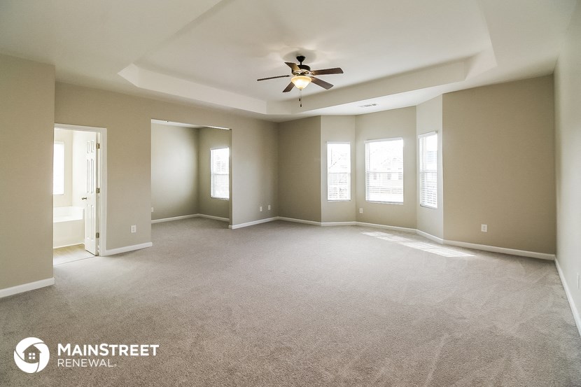 an empty living room with a ceiling fan