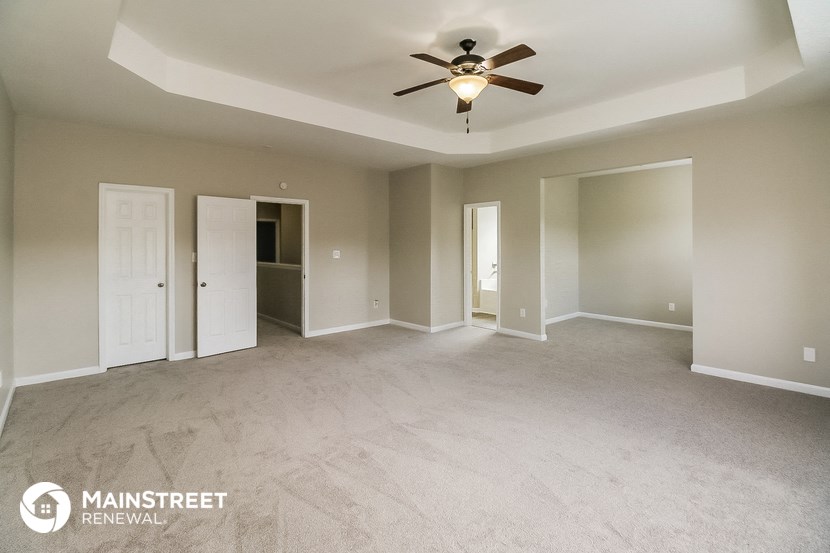 an empty living room with a ceiling fan