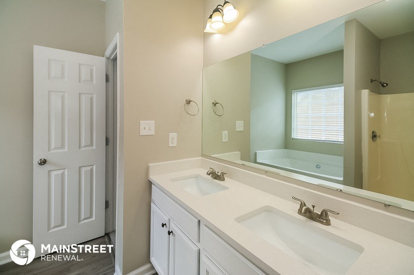 the bathroom has a large mirror and two sinks