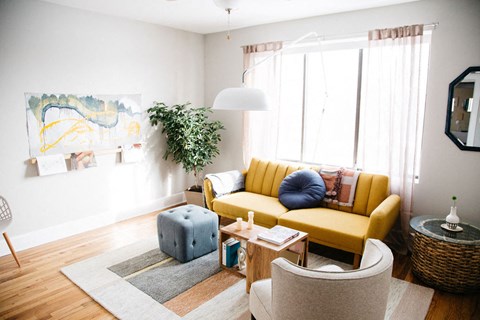 a living room with a yellow couch and a table