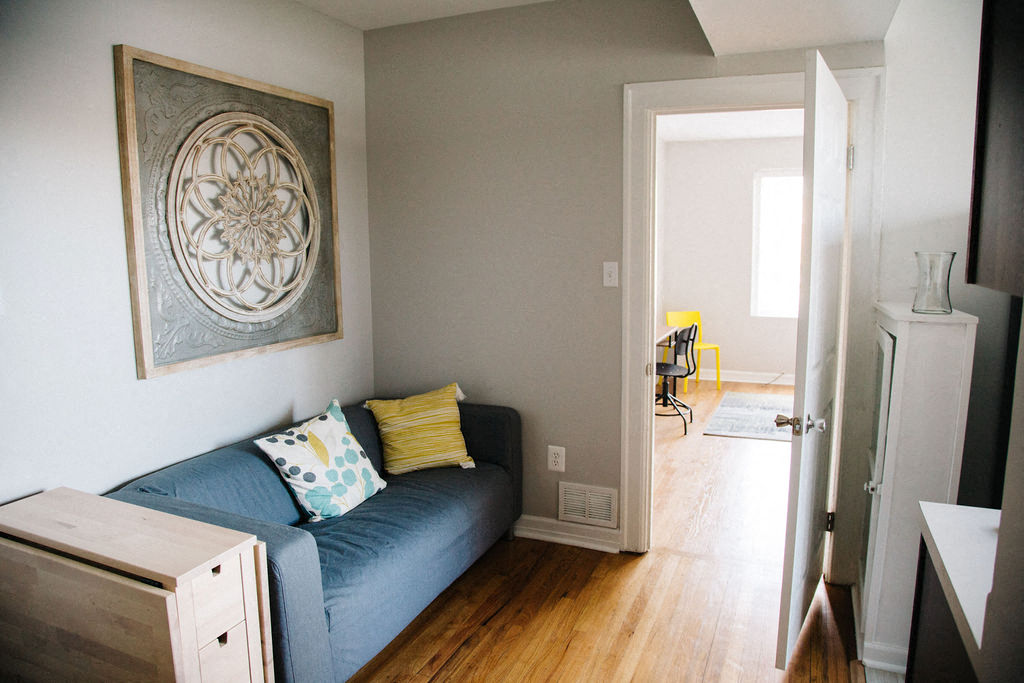 a small living room with a blue couch and a painting