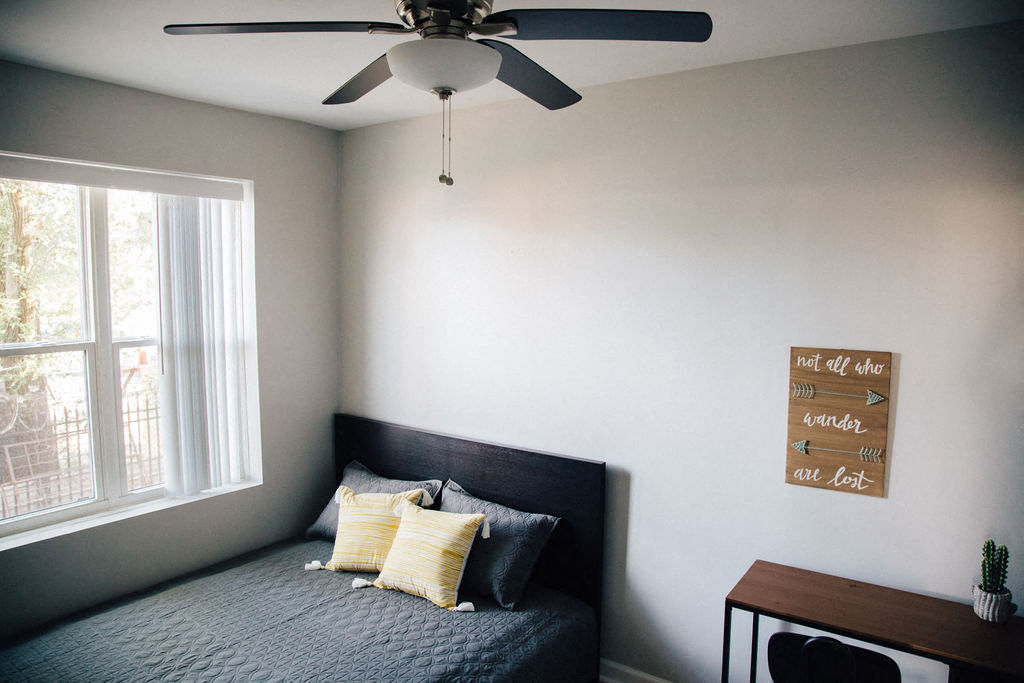 a bedroom with a bed and a ceiling fan