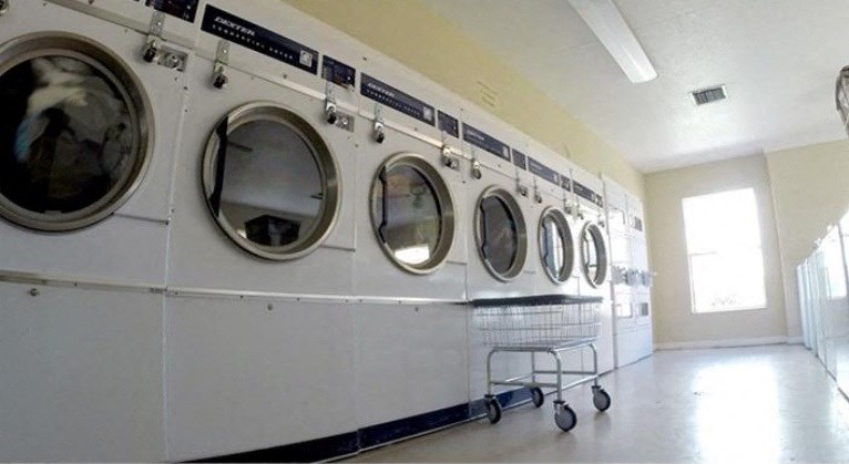 a row of washers and dryers in a laundry room