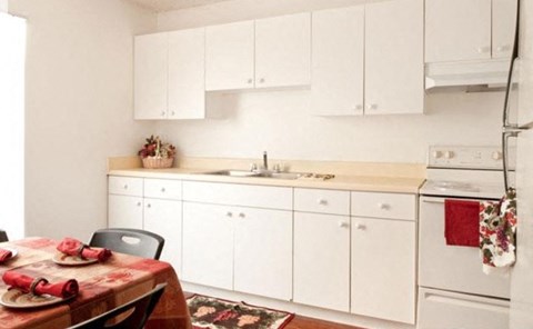 a kitchen with white cabinets and a table