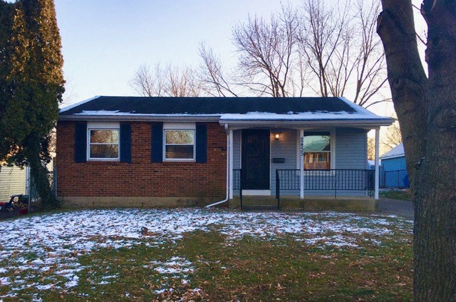 a small brick house with snow on the ground