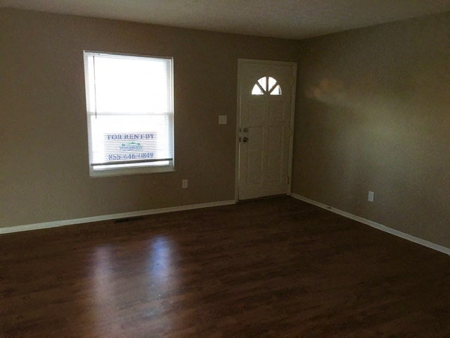 an empty living room with a door and a window