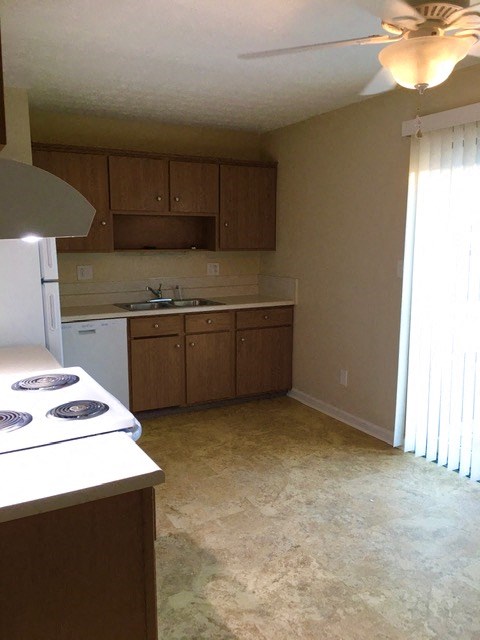 an empty kitchen with a stove and a sink