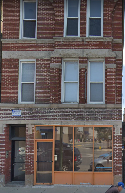 the front of a brick building with glass windows