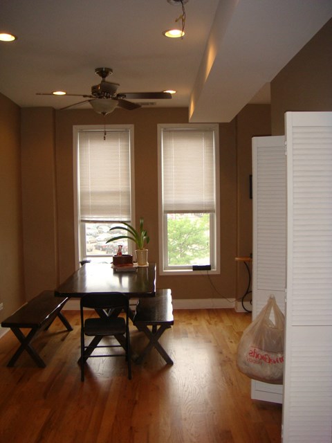 a dining room with a table and chairs and two windows