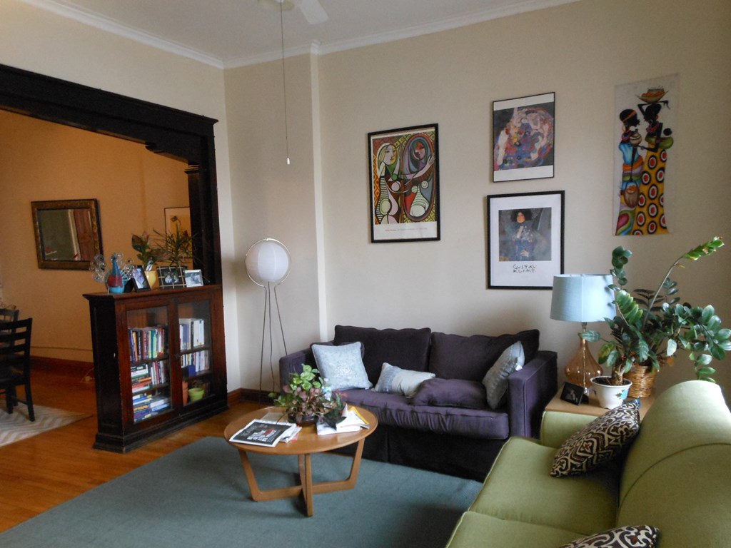 A living room with a green couch and a wooden coffee table.