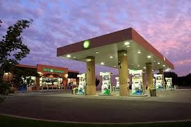 a gas station at night with a purple sky