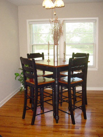 a dining room table with chairs and a window