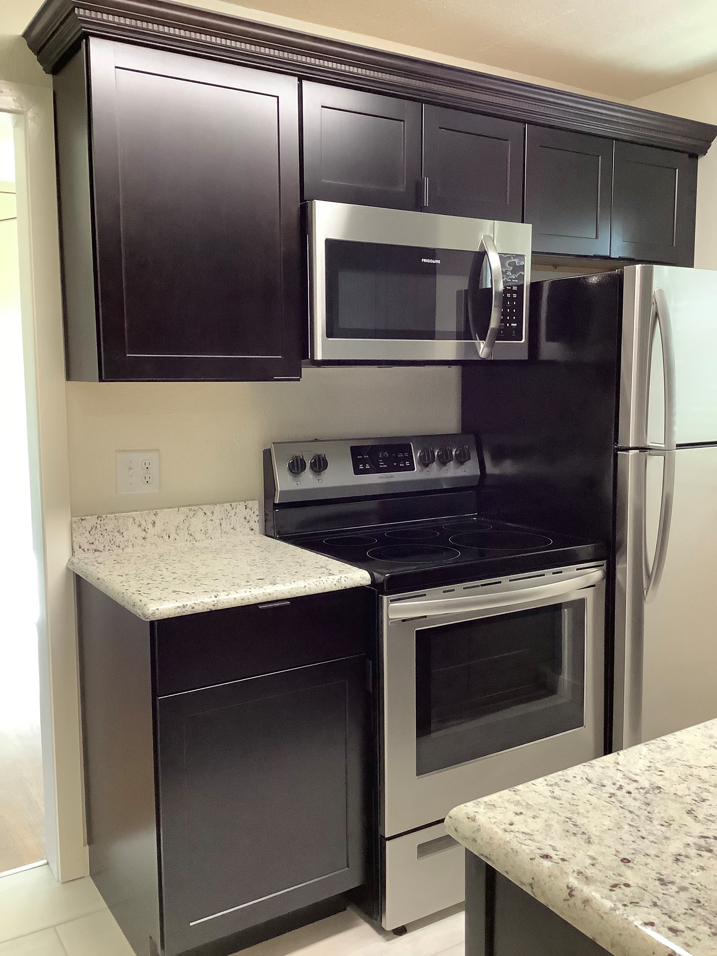 a kitchen with stainless steel appliances and black cabinets
