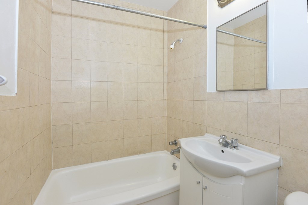 a bathroom with a sink and a tub and a mirror