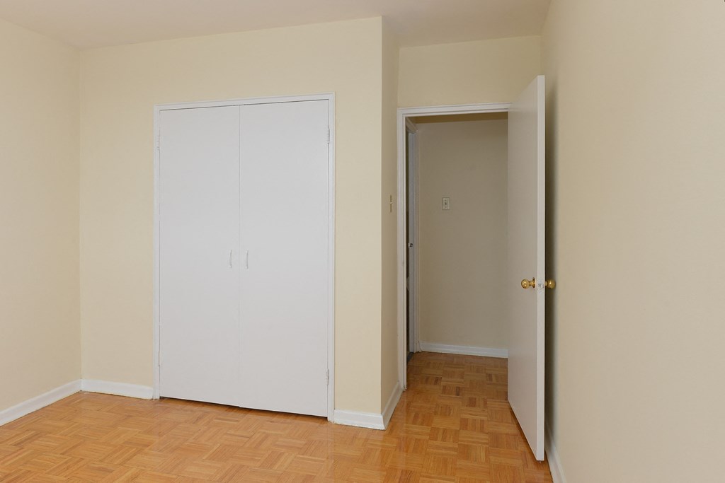 an empty room with a closet and a door open