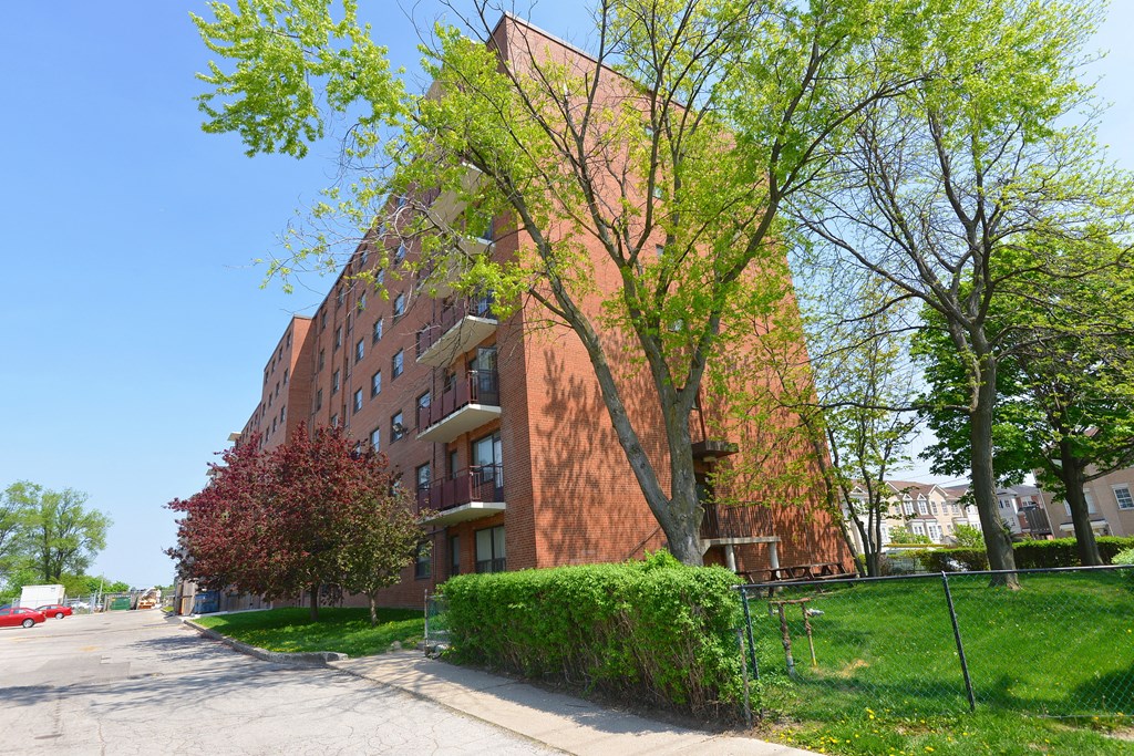 a tall red brick building on the side of a street