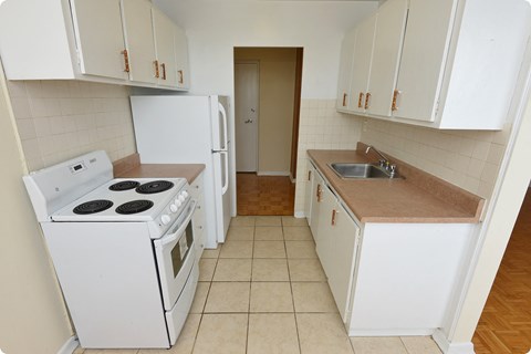 an empty kitchen with a stove refrigerator and sink