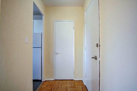 an empty room with a refrigerator and a door