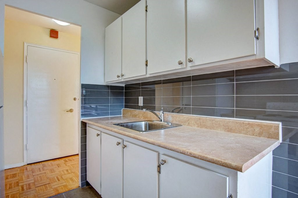 a kitchen with white cabinets and a sink