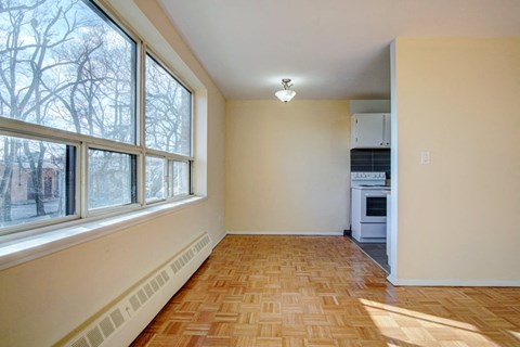 an empty living room with large windows and a wood floor