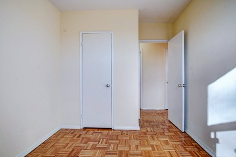 an empty room with three doors and a wooden floor