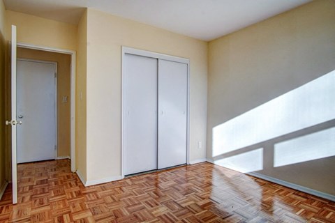 an empty living room with a hard wood floor and white doors