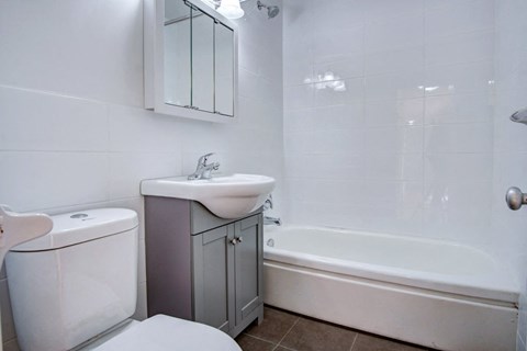 a white bathroom with a sink and a tub