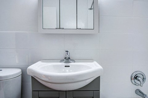 a white bathroom with a sink and a mirror