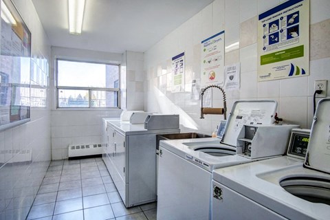 an empty laundry room with washing machines and a sink