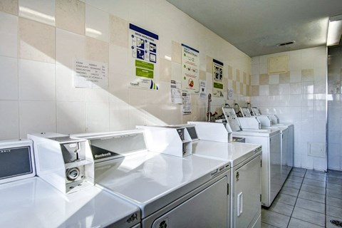a kitchen with a bunch of washing machines and sinks
